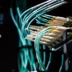 Detailed view of network cables plugged into a server rack in a data center.